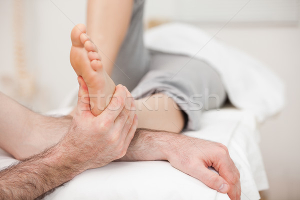 Woman having a foot massage while bending a leg in a medical room Stock photo © wavebreak_media