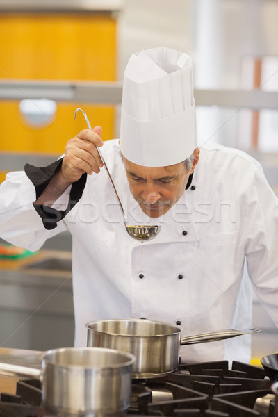 Stock photo: Chef about to taste soup in kitchen