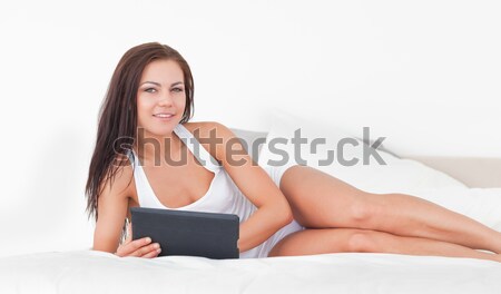 Young woman sitting on bed Stock photo © wavebreak_media