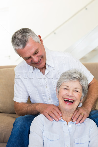 Man giving his senior wife a shoulder rub who is smiling at came Stock photo © wavebreak_media