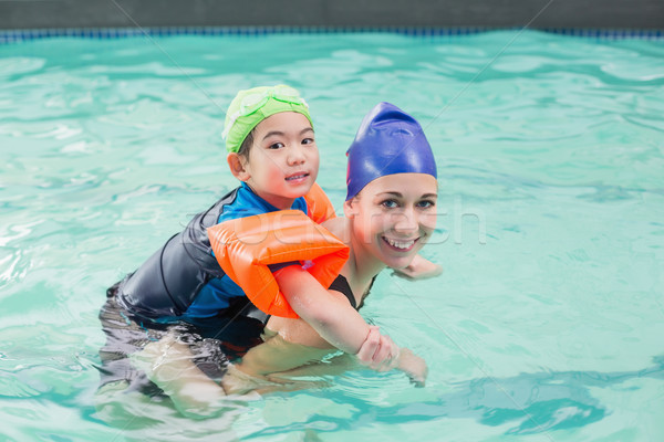 Cute little boy learning to swim with coach Stock photo © wavebreak_media