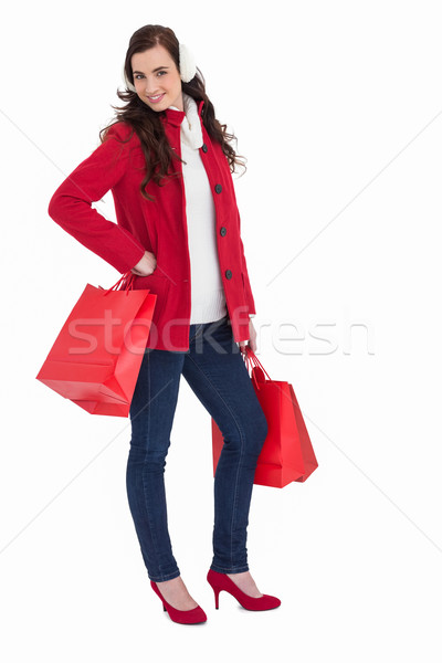 Cheerful brunette in winter clothes posing and holding shopping  Stock photo © wavebreak_media