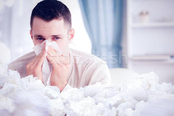 Composite image of young man blowing his nose Stock photo © wavebreak_media