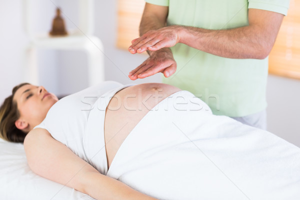 Relaxed pregnant woman getting reiki treatment Stock photo © wavebreak_media