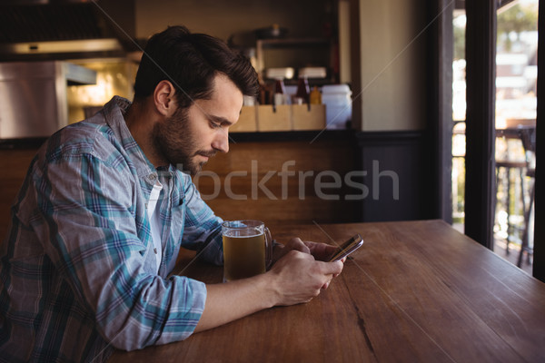 Man using mobile phone while having beer Stock photo © wavebreak_media