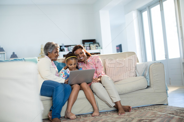 Famille heureuse utilisant un ordinateur portable salon maison internet heureux [[stock_photo]] © wavebreak_media