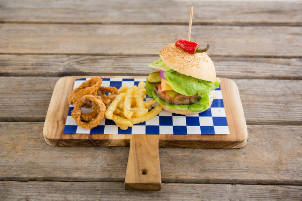 Foto stock: Hamburguesa · cebolla · anillos · tabla · de · cortar · mesa