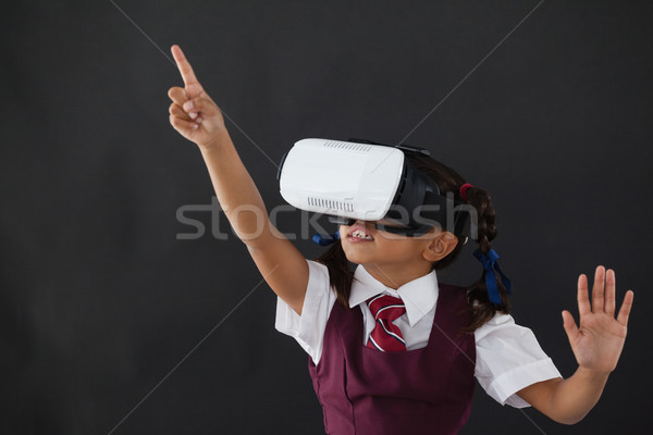 Schoolgirl using virtual reality headset against blackboard Stock photo © wavebreak_media