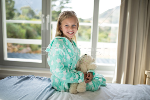 Glimlachend meisje teddybeer bed slaapkamer Stockfoto © wavebreak_media