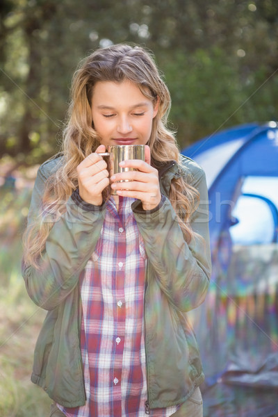 Pretty blonde camper enjoying beverage in front of tent Stock photo © wavebreak_media