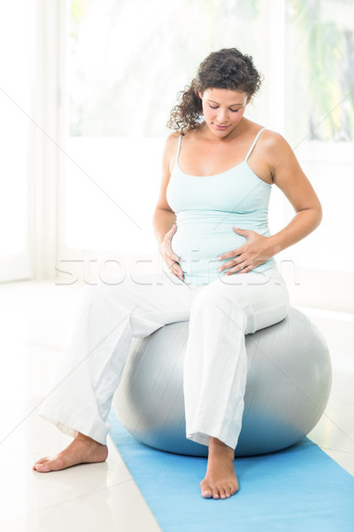 Femeie gravida atingere burtă şedinţei exercita bilă Imagine de stoc © wavebreak_media