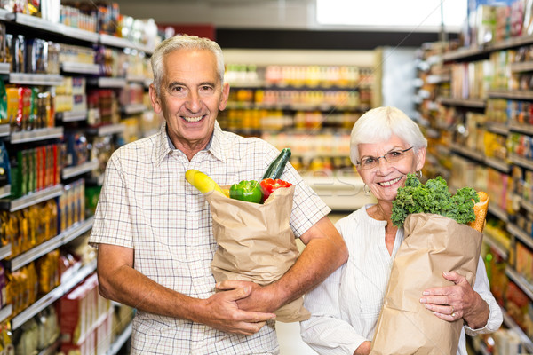 Mosolyog idős pár tart élelmiszer szatyrok áruház Stock fotó © wavebreak_media