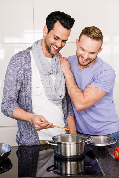 Sorridente homossexual casal cozinha comida Foto stock © wavebreak_media