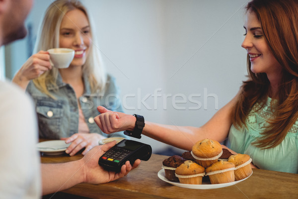 Happy customer with smart watch paying at cafe Stock photo © wavebreak_media