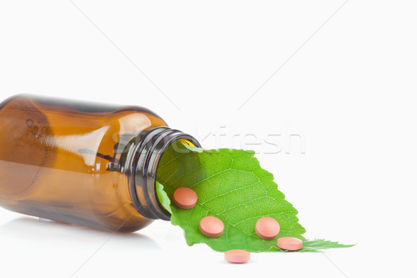 Leaf and pills in a small bottle against a white background Stock photo © wavebreak_media