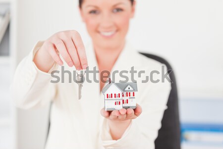 Close up of a brunette showing a miniature house with the camera focus on the object Stock photo © wavebreak_media