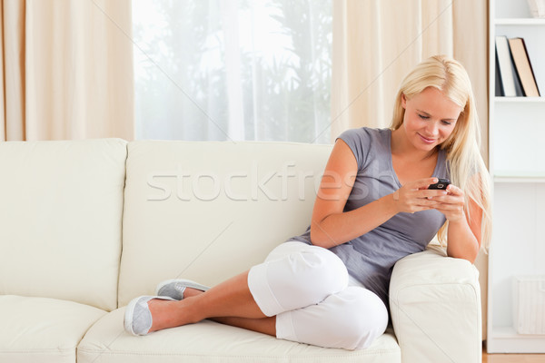 женщину сидят диван телефон Сток-фото © wavebreak_media