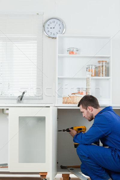 Portrait of a handsome handyman fixing a door in a kitchen Stock photo © wavebreak_media