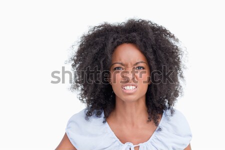 Woman with curly hairstyle showing teeth as an indication of her anger Stock photo © wavebreak_media
