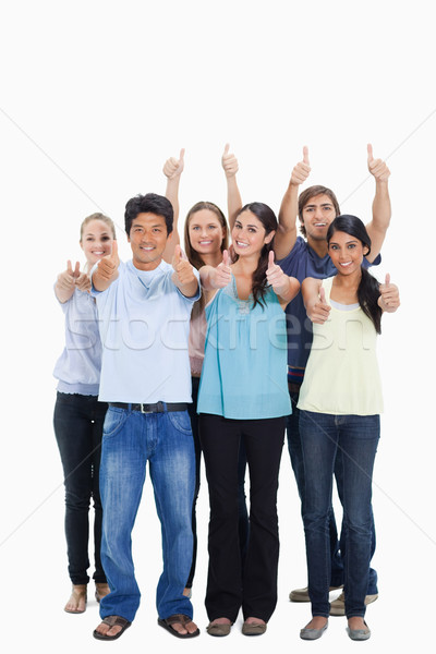 People smiling together and approving with the thumbs-up against white background Stock photo © wavebreak_media