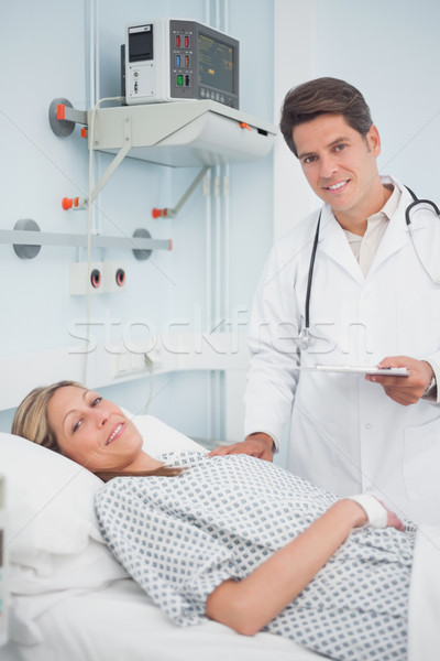 Doctor and patient smiling in hospital ward Stock photo © wavebreak_media