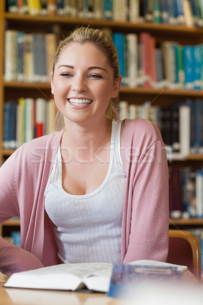 Student smiling at the library sitting at desk Stock photo © wavebreak_media