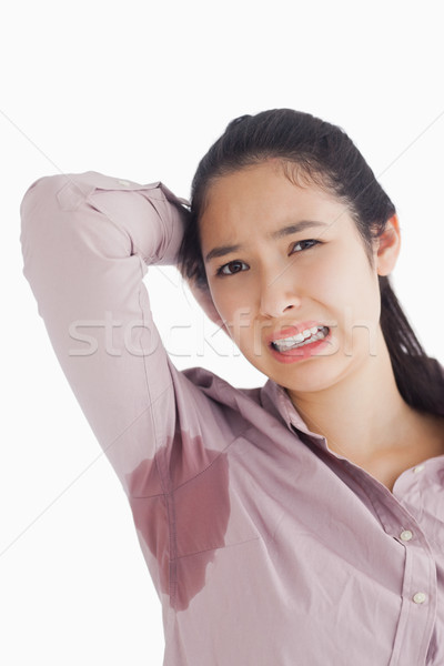 Woman appalled by her sweat patches on white background Stock photo © wavebreak_media