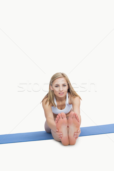Stock photo: Portrait of young woman performing stretching exercise on yoga m