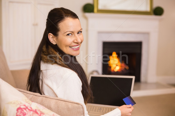 Femme achats en ligne portable carte de crédit maison salon [[stock_photo]] © wavebreak_media