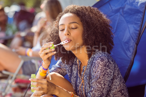 Carefree hipster blowing bubbles in tent Stock photo © wavebreak_media