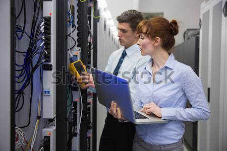 Team of technicians using digital cable analyser on servers Stock photo © wavebreak_media