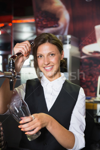 Happy barmaid pulling a pint of beer Stock photo © wavebreak_media