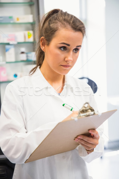 Junior pharmacist writing on clipboard Stock photo © wavebreak_media
