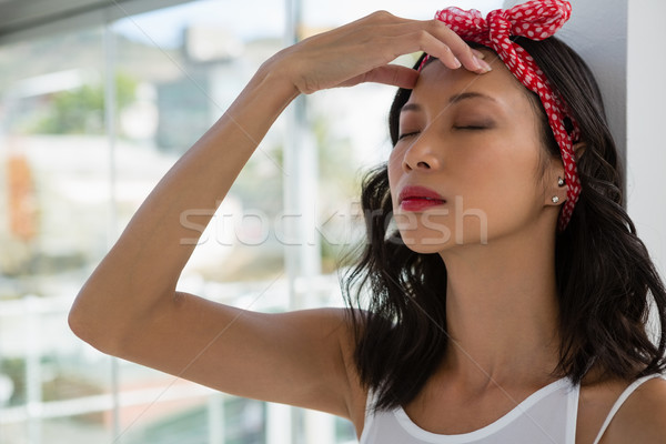 Tensed businesswoman with eyes closed leaning on wall Stock photo © wavebreak_media