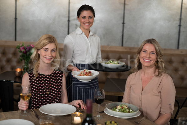 Portrait of happy waitress and customers at dining table Stock photo © wavebreak_media