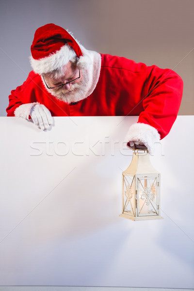 Stock photo: Santa Claus holding christmas lantern on white board