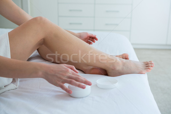 Woman applying moisturizer cream on her leg in bedroom Stock photo © wavebreak_media