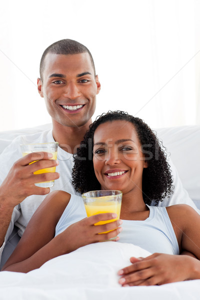 Enamored couple drinking lying on their bed Stock photo © wavebreak_media