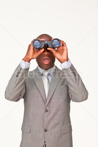 Surprised Afro-American businessman looking through binoculars Stock photo © wavebreak_media