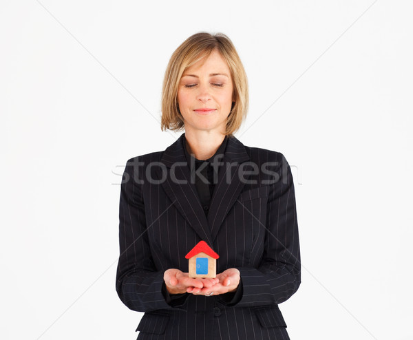 Cute mature businesswoman holding a house against a white background Stock photo © wavebreak_media