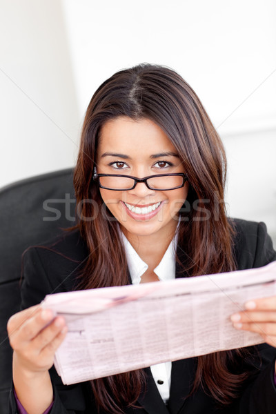 Charming asian businesswoman holiding a newspaper smiling at the camera in her office Stock photo © wavebreak_media