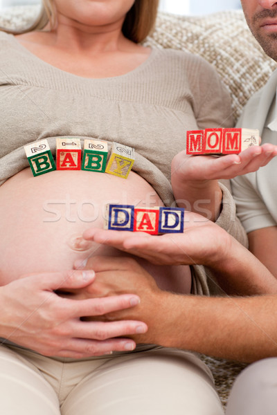 Close up of future parents holding cubes forming the words mom ,dad and baby  Stock photo © wavebreak_media