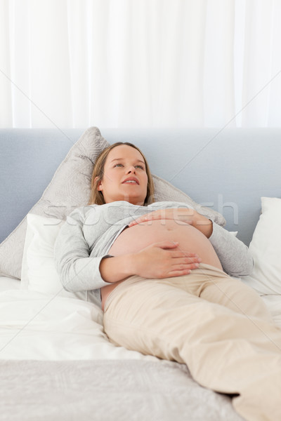 Joli femme enceinte lit maison sourire [[stock_photo]] © wavebreak_media