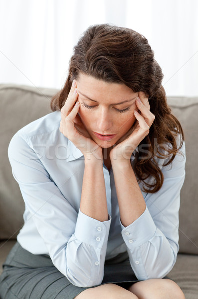 Pretty businesswoman having a headache sitting on the sofa Stock photo © wavebreak_media