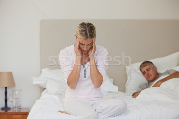 Woman having a headache while her husband is sleeping Stock photo © wavebreak_media
