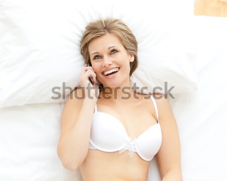 Blonde woman yawning sitting on her bed Stock photo © wavebreak_media