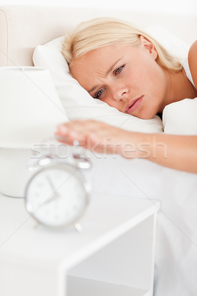 Portrait of a woman awaken by an alarmclock  in her bedroom Stock photo © wavebreak_media