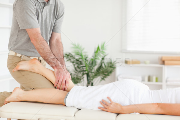 Stock photo: A masseur massages a woman's leg 
