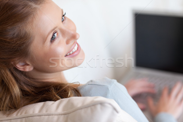 Shadowing smiling young woman working on her laptop Stock photo © wavebreak_media