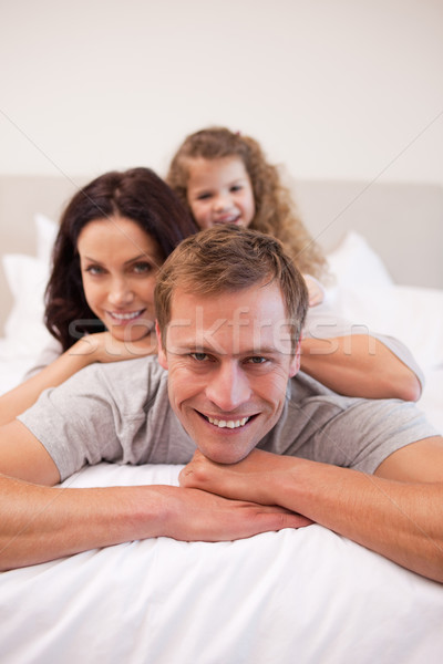 Alegre jovem família relaxante cama juntos Foto stock © wavebreak_media